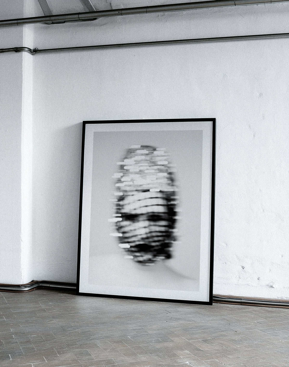Framed black and white portrait on a plain wall.