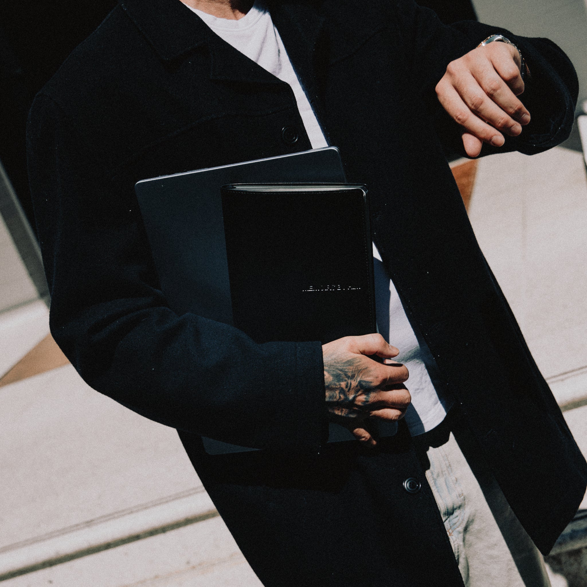 Person holding a black book with a blurred background